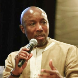 A photo of Magnus Conteh, holding a microphone