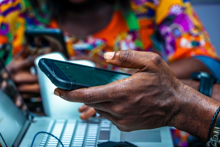 A hand of an African person holding a mobile phone