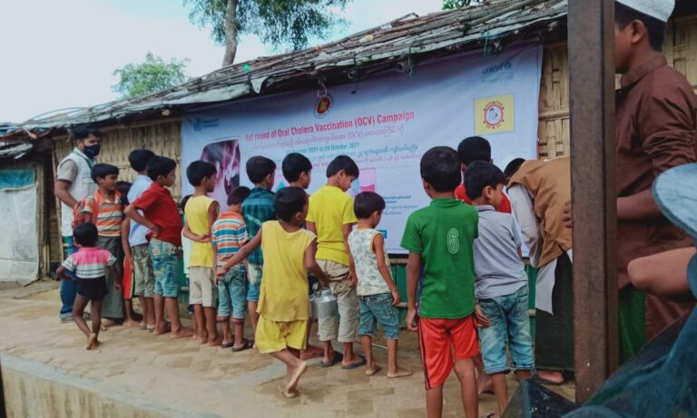 Rohingya children in the camps looking at a poster developed for increasing awareness of Oral Cholera Vaccination in Bangladesh.