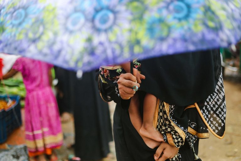 Rohingya woman and child hidden under umbrella