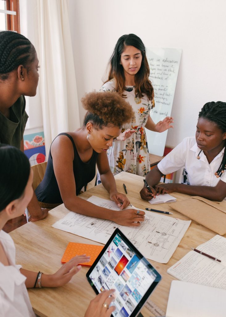 group working around a table with whiteboards, pen and a tablet