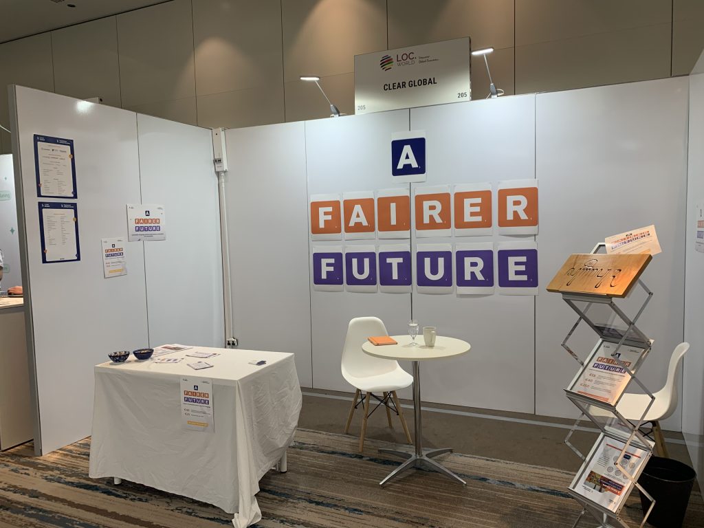 Image of a white booth with the words "a fairer future" written on paper tiles in orange and purple