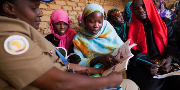 18 February 2014. Abu Shouk: UNAMID police  officer Mwamini Rwantale (from Tanzania) interacts with women who receive English classes in Abu Shouk camp for Internally Displaced Persons (IDP), North Darfur conducted by a volunteer teacher and facilitated by the UNAMID police. Nearly 100 women, mostly adult and mothers, attend these classes three times a week in a school in the camp with materials (exercise books, notebooks, blackboards and chalks) provided by the UNAMID police section.  
Photo by Albert González Farran, UNAMID